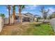 Expansive backyard includes a screened lanai, a privacy fence, and mature palm trees creating an outdoor living area at 5718 Westhaven Cv, Bradenton, FL 34203