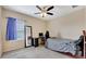 Neutral bedroom with a ceiling fan, a window with curtains, and a full-length mirror for getting ready at 5718 Westhaven Cv, Bradenton, FL 34203