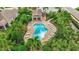 Overhead view of community pool surrounded by lounge chairs, landscaping and covered area at 5718 Westhaven Cv, Bradenton, FL 34203