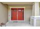 Close-up of the red double front doors featuring glass panes, and neutral exterior at 5718 Westhaven Cv, Bradenton, FL 34203