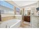 Bright bathroom featuring a tub, glass enclosed shower, vanity with double sinks and lots of natural light at 5821 Hevena Ct, Palmetto, FL 34221