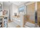 Bathroom showcasing a tub, glass-enclosed shower, vanity, and natural light from a nearby window at 5821 Hevena Ct, Palmetto, FL 34221