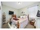 Cozy bedroom with a patterned bed, dresser with TV, and natural light from a window at 5821 Hevena Ct, Palmetto, FL 34221