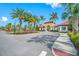 Community clubhouse featuring a covered entrance, red tile roof, ample parking and lush landscaping with palm trees at 5821 Hevena Ct, Palmetto, FL 34221