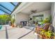 Relaxing covered patio with comfortable seating, a ceiling fan, and a view of the screened pool area at 5821 Hevena Ct, Palmetto, FL 34221