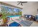 Covered patio featuring cozy wicker furniture, a ceiling fan, and a lovely view of the screened pool at 5821 Hevena Ct, Palmetto, FL 34221