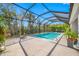 Large screened lanai with a beautiful pool, plenty of space for lounging, and tropical landscaping at 5821 Hevena Ct, Palmetto, FL 34221