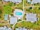 Aerial view of community amenities, including a pool and shuffleboard, nestled among lush landscaping and residential buildings at 5855 Palm Ln # B21, Bradenton, FL 34207