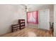 Entryway with wood laminate flooring, storage shelves and window with pink curtains at 5855 Palm Ln # B21, Bradenton, FL 34207