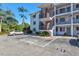 Exterior side view of apartment with parking and green landscaping on a sunny day at 5855 Palm Ln # B21, Bradenton, FL 34207