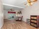 Carpeted Living Room open to screened-in back porch with ceiling fans and wood-look vinyl flooring at 5855 Palm Ln # B21, Bradenton, FL 34207