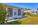 Cozy back patio with privacy screens, a door to the home, and a well-kept lawn at 6016 Hibiscus Dr, Bradenton, FL 34207