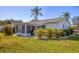 Spacious backyard featuring a patio, manicured lawn, tropical plants, and a well-maintained exterior at 6016 Hibiscus Dr, Bradenton, FL 34207