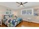 Inviting bedroom with a tropical-themed bedspread, wood floors, and bright natural light at 6016 Hibiscus Dr, Bradenton, FL 34207