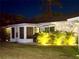 Exterior view of a charming home featuring an enclosed sunroom and lush landscaping at 6016 Hibiscus Dr, Bradenton, FL 34207