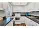 Well-equipped kitchen featuring white cabinetry, modern appliances, and sleek black countertops at 6016 Hibiscus Dr, Bradenton, FL 34207