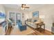 Comfortable living room featuring a ceiling fan, beach-themed decor, and a sliding glass door at 6016 Hibiscus Dr, Bradenton, FL 34207