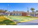 Community shuffleboard courts with palm trees and clubhouse under a clear blue sky at 6016 Hibiscus Dr, Bradenton, FL 34207