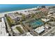 Aerial view showcases the beachside condo community, lush landscaping, and convenient tennis courts at 6500 Sunset Way # 311, St Pete Beach, FL 33706