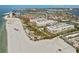 An aerial view highlighting the beachfront condo complex with a pool and pristine sandy beach at 6500 Sunset Way # 311, St Pete Beach, FL 33706