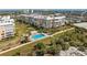 The aerial view showcases the condo complex, lush grounds with a pool, and beach access at 6500 Sunset Way # 311, St Pete Beach, FL 33706