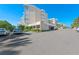 Condo building exterior featuring private balconies, with well-maintained landscaping at 6500 Sunset Way # 311, St Pete Beach, FL 33706