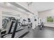 Well-equipped gym features treadmills, elliptical, rowing machine, and mirrored wall at 6500 Sunset Way # 311, St Pete Beach, FL 33706