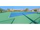 Outdoor tennis court featuring vibrant colors and professional netting at 6500 Sunset Way # 311, St Pete Beach, FL 33706