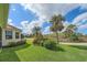 Spacious backyard with lush green lawn, beautiful landscaping, and views of mature palm trees at 6540 Tailfeather Way, Bradenton, FL 34203