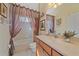 Bathroom with a bath/shower, soft lighting, brown curtains, and neutral tones at 6540 Tailfeather Way, Bradenton, FL 34203