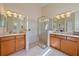 Well-lit bathroom featuring separate vanities, a glass enclosed shower, and tile flooring at 6540 Tailfeather Way, Bradenton, FL 34203