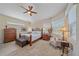 Inviting bedroom with neutral tones, two windows, decorative chair, and dark wood furnishings at 6540 Tailfeather Way, Bradenton, FL 34203