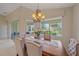 Dining area with a chandelier, large window, and view of greenery at 6540 Tailfeather Way, Bradenton, FL 34203