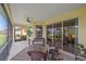 Inviting screened lanai with wicker seating, ceiling fan, and sliding doors leading to outdoor living spaces at 6540 Tailfeather Way, Bradenton, FL 34203