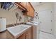 Functional laundry room featuring a utility sink, overhead cabinets, and modern washing machine at 6540 Tailfeather Way, Bradenton, FL 34203