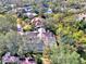 Aerial image featuring the home and its screened-in pool, surrounded by a dense canopy of mature trees at 67 Sugar Mill Dr, Osprey, FL 34229