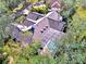 An aerial view showcases a tile roof with a screened-in pool, all surrounded by the property's mature trees at 67 Sugar Mill Dr, Osprey, FL 34229