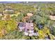 An aerial view of the home nestled among mature trees and lush landscaping with a screened-in pool at 67 Sugar Mill Dr, Osprey, FL 34229