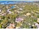 High angle aerial of homes in a wooded neighborhood with an inter-coastal waterway in the distance at 67 Sugar Mill Dr, Osprey, FL 34229