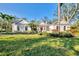 Beautiful home with a well-kept lawn, palm trees, and a red door at 67 Sugar Mill Dr, Osprey, FL 34229