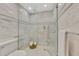 A frameless shower with white marble tiling and a shower head at 67 Sugar Mill Dr, Osprey, FL 34229