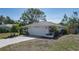 Single-story home featuring a two-car garage and mature tropical trees at 6705 20Th W Ave, Bradenton, FL 34209