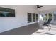 This spacious sunroom features gray painted concrete floors, plenty of sunlight and a ceiling fan at 6705 20Th W Ave, Bradenton, FL 34209