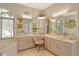 Bright bathroom with a corner tub, lots of vanity space with cabinets, and a gold-accented chair at 746 Plymouth St, Sarasota, FL 34242