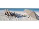 Relaxing beach scene with chairs, umbrella, driftwood, and toys on white sand at 746 Plymouth St, Sarasota, FL 34242