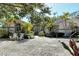 Charming home featuring a gravel driveway, lush landscaping and front porch with two white Adirondack chairs at 746 Plymouth St, Sarasota, FL 34242