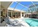 The screened-in pool offers lounge chairs, a tile pool deck and easy access to the home through sliding glass doors at 746 Plymouth St, Sarasota, FL 34242