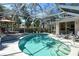 Stunning screened-in pool featuring a curved design and sun loungers, perfect for outdoor relaxation at 746 Plymouth St, Sarasota, FL 34242