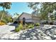 Charming home featuring a gravel driveway and meticulously landscaped yard with lush greenery at 746 Plymouth St, Sarasota, FL 34242