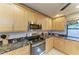 Galley kitchen with maple cabinets, granite countertops, and stainless steel appliances at 7921 4Th W Ave, Bradenton, FL 34209